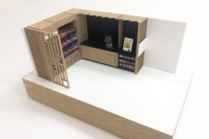 1:12 scale model of a micromarket. The model is made from laser cut gloss white acrylic and oak. It is animated with scale model food and till ans ditting on a veneered baseboard.
