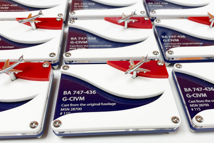 Laser cut acrylic display stand for a model BA airplane. Laser cut from blue, clear, white and red acrylic with model details engraved on the clear acrylic.