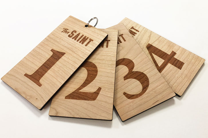 Laser cut and engraved cherry wood keyring fobs for hotel keys. Laser etched with room numbers and hotel logo..
