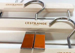 Laser engraved wood coat hangers with L'Estrange London logo.