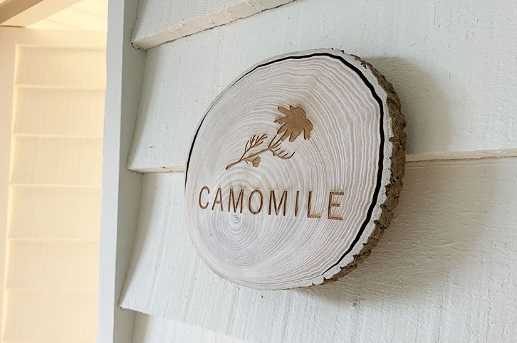 Engraved, natural birch wood slice hanging on a wall.