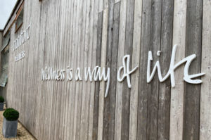 Large white, cnc machined, sign letters mounted on a wood clad wall for Bamford Wellness Spa.