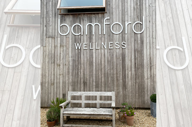 Large white, cnc machined, sign letters mounted on a wood clad wall for Bamford Wellness Spa.