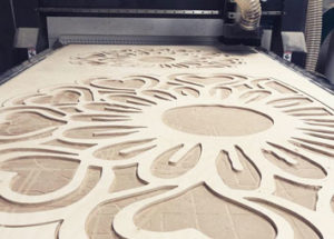 CNC mahined flower from plywood on the machine.