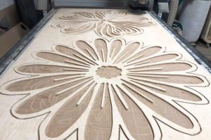 CNC mahined flower from plywood on the machine.