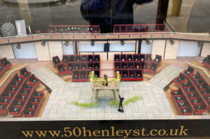 Window display minature model based on the Royal Shakespheare Theatre for 50 Henley Street. Rings are displayed in the model seats. The model shows a scene of Romeo and Juliet.