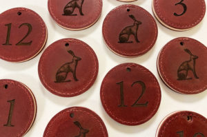 Laser engraved red leather keyfobs with an image of a hare and room numbers.