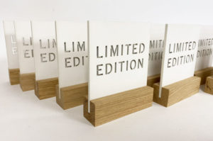 Bespoke laser cut plywood shop signs. Painted white with a solid oak slotted base.