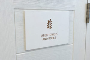 Painted white wood sign, laser engraved with information.