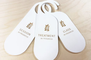 Laser engraved white wood signs to hang on tratment room door handles. Laser engraved information.