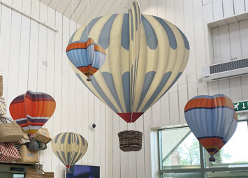 Shop display of wood slot together hanging hot air balloons for Daylesford Farm.